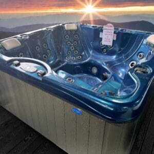 Blue hot tub on deck with mountain sunset