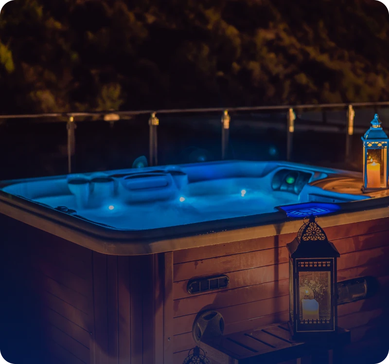 A cozy hot tub glowing with blue lights at night.